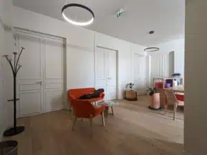 Rénovation de bureaux : l'espace accueil transformé : le salon d'accueil, porte-manteaux, luminaire